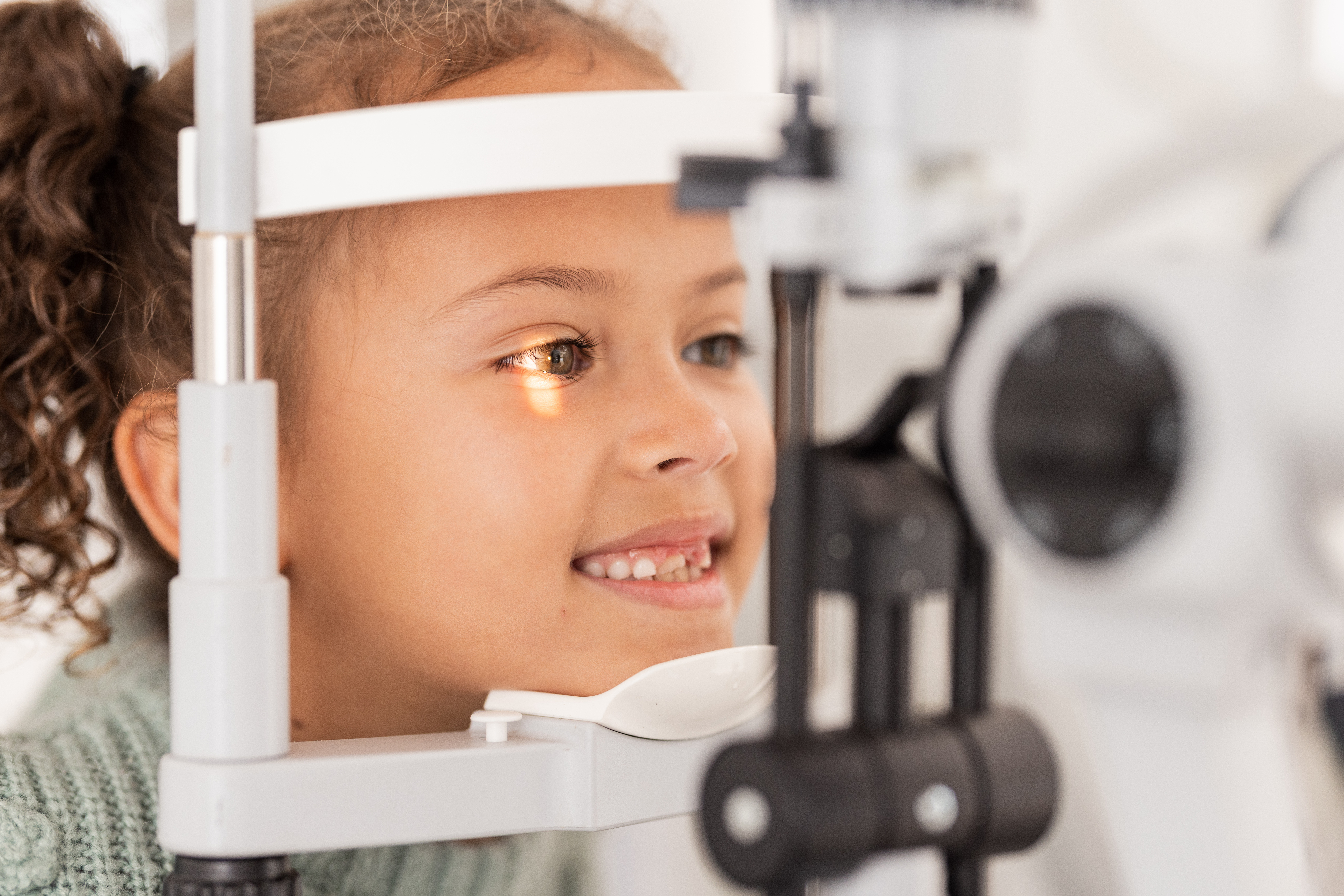 Vision, test and girl for eye exam in the opthalmologist office with equipment for glasses. Optics, examination and female child testing for eyecare health or wellness for optometry for healthcare.